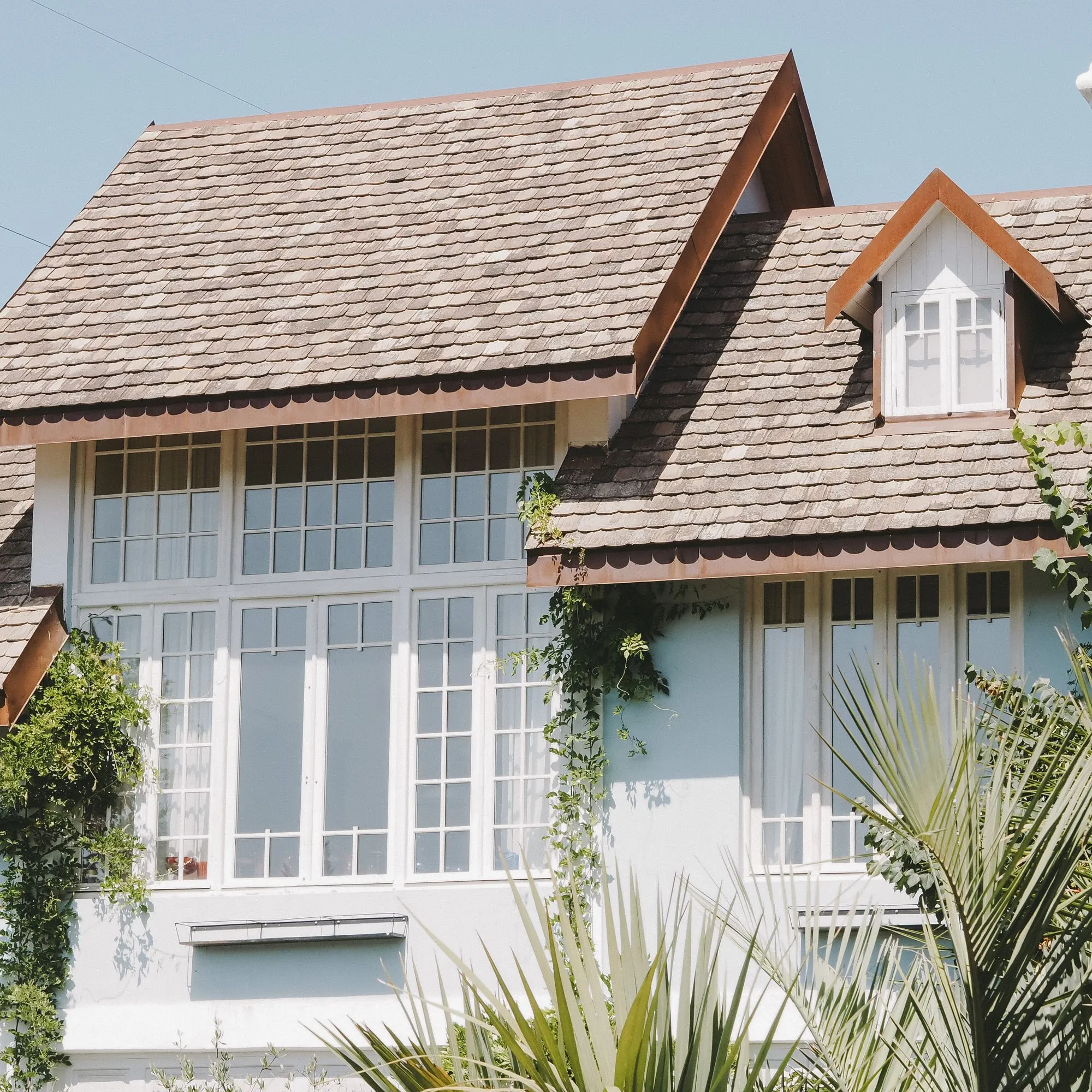 House with a shingled roof and large front windows